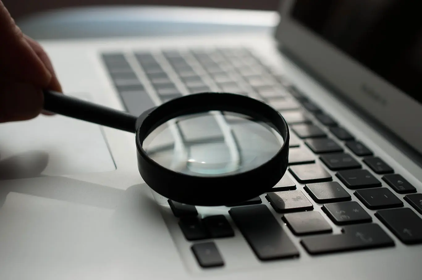magnifying glass placed over a laptop keyboard